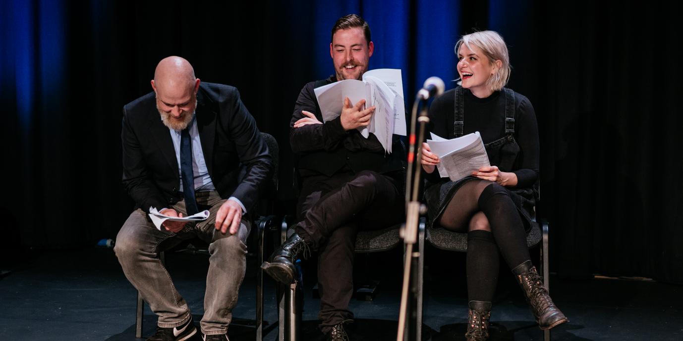 Comedians laughing with scripts