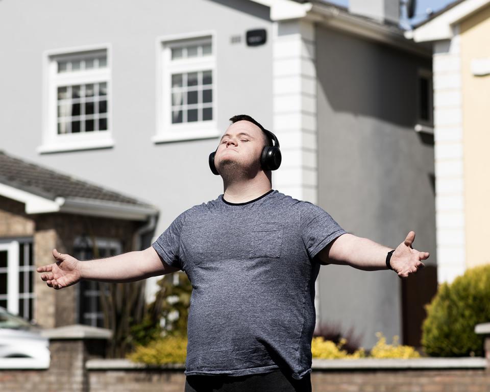 Mark with arms outstretched, wearing earphones