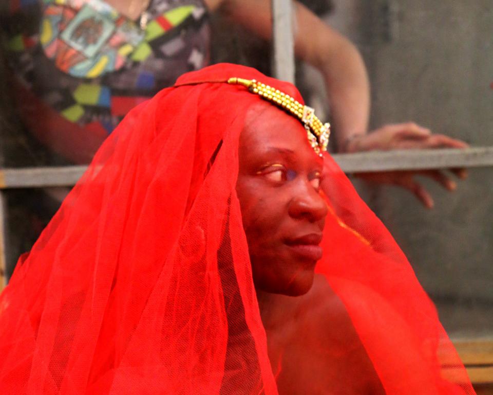 Black Jam, Woman wearing red veil, with woman looking through a window behind her