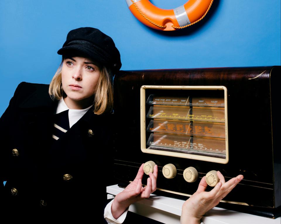 Image of lighthouse keeper turning dial on an old wireless radio