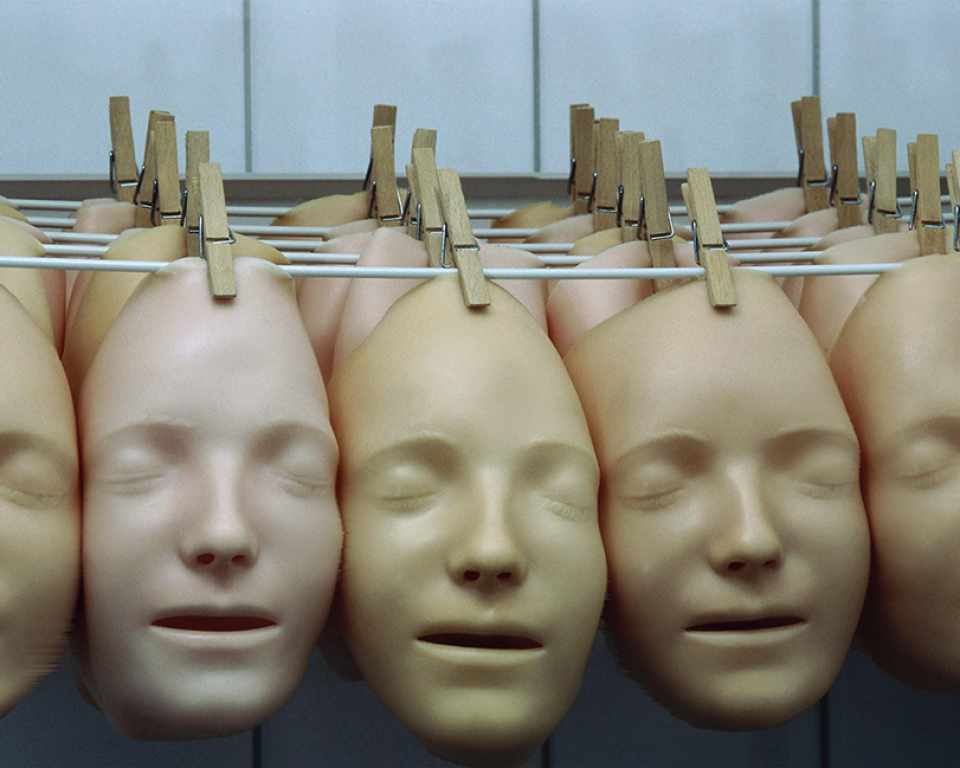 Multiple silicone faces handing from a line with a peg
