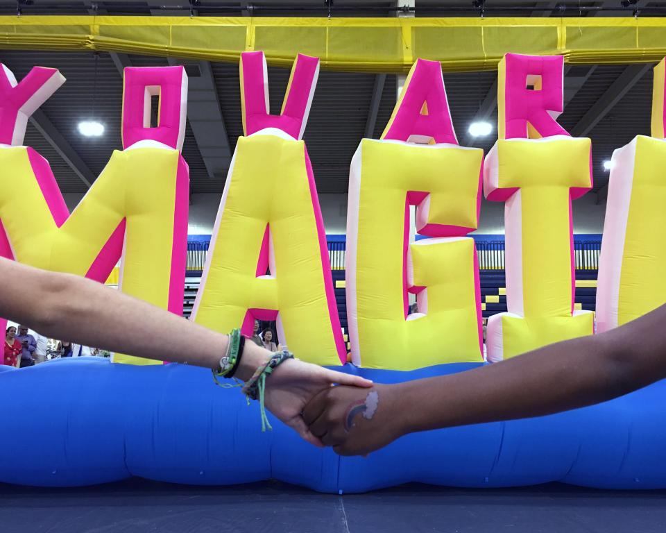 Two hands holding in front of inflatable artwork