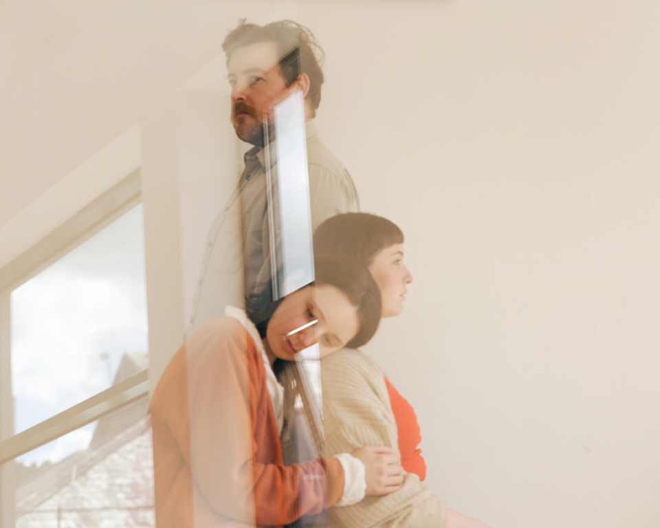 Reflected image of three people in close embrace