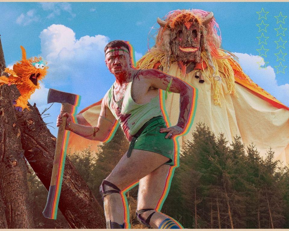 A man in a costume wields an axe, standing beside a large, menacing monster in a dramatic setting.