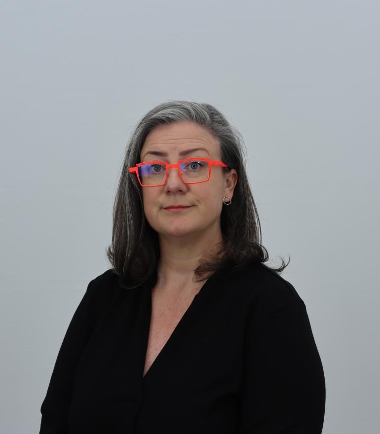 a white woman wearing pink glasses