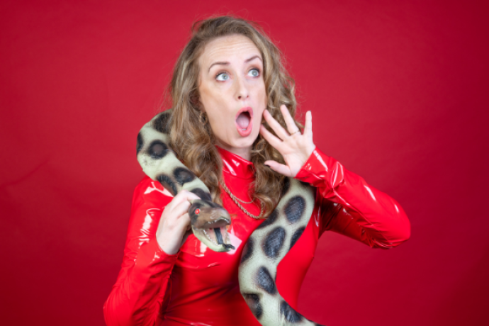 A women in red pleather with a fake snake around her neck