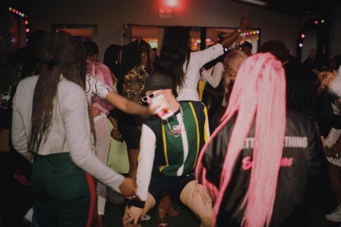 Photo of people dancing at a club night with pin lighting.