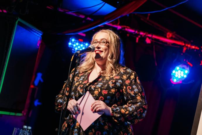 Ruth McGowan standing on stage speaking into a microphone