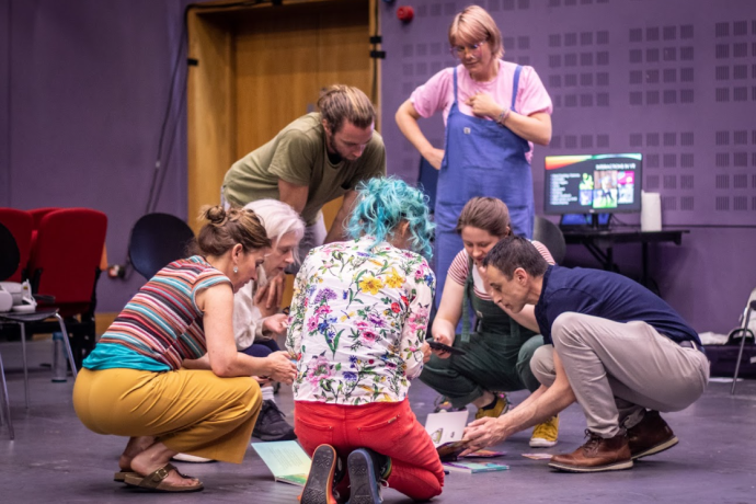 A group of people hunched in a group together problem solving