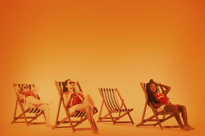 Three people sit in striped deckchairs. There is an hot orange glow throughout. 