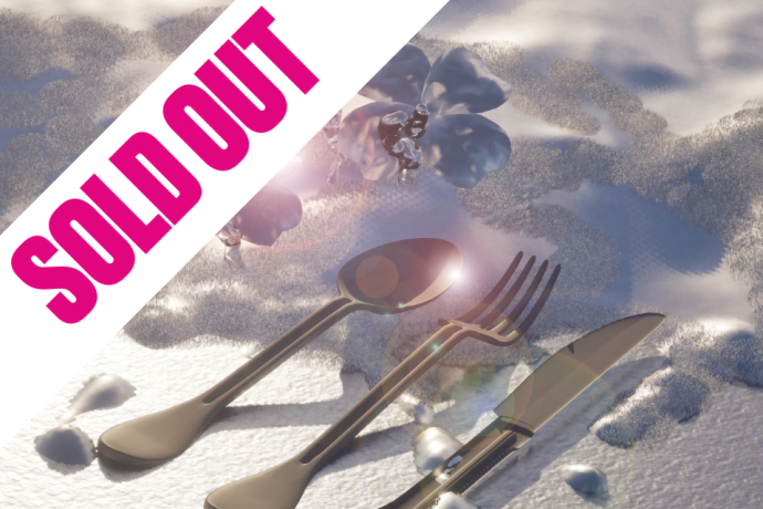 A spoon, fork, and knife rest on a textured white surface with a shadow and glare; two metallic flowers and bright light are in the background.
