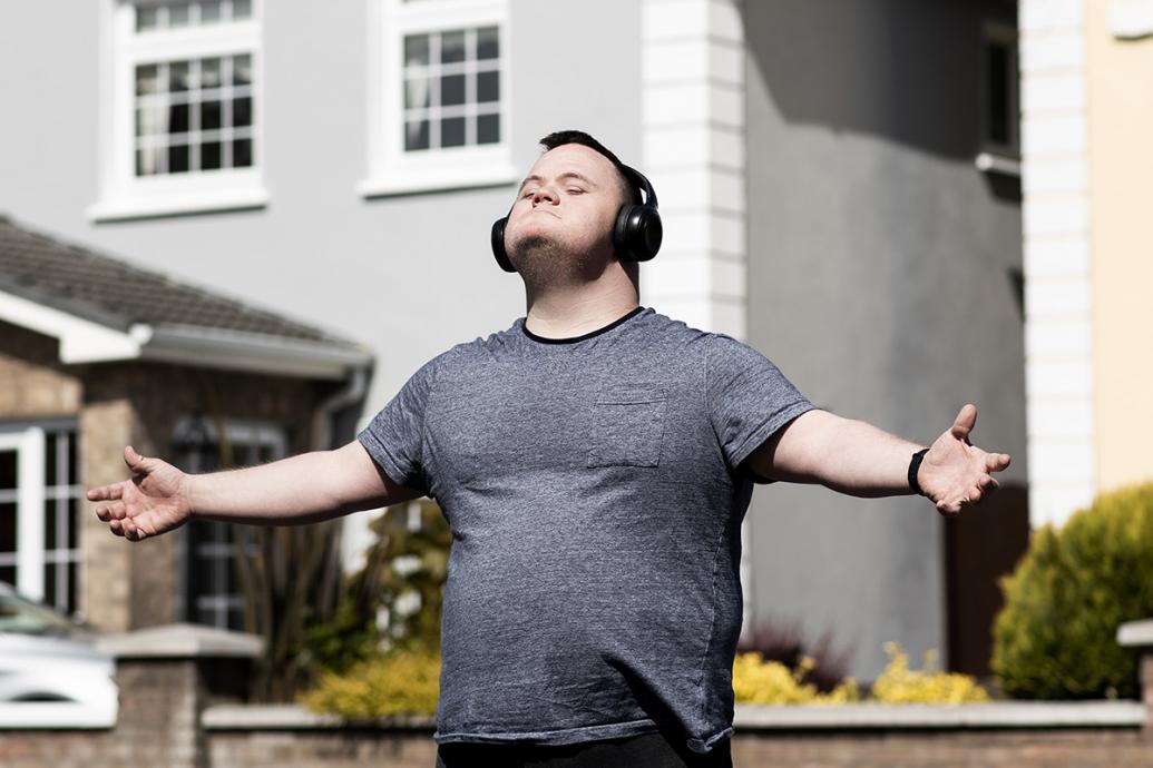 Mark with arms outstretched, wearing earphones