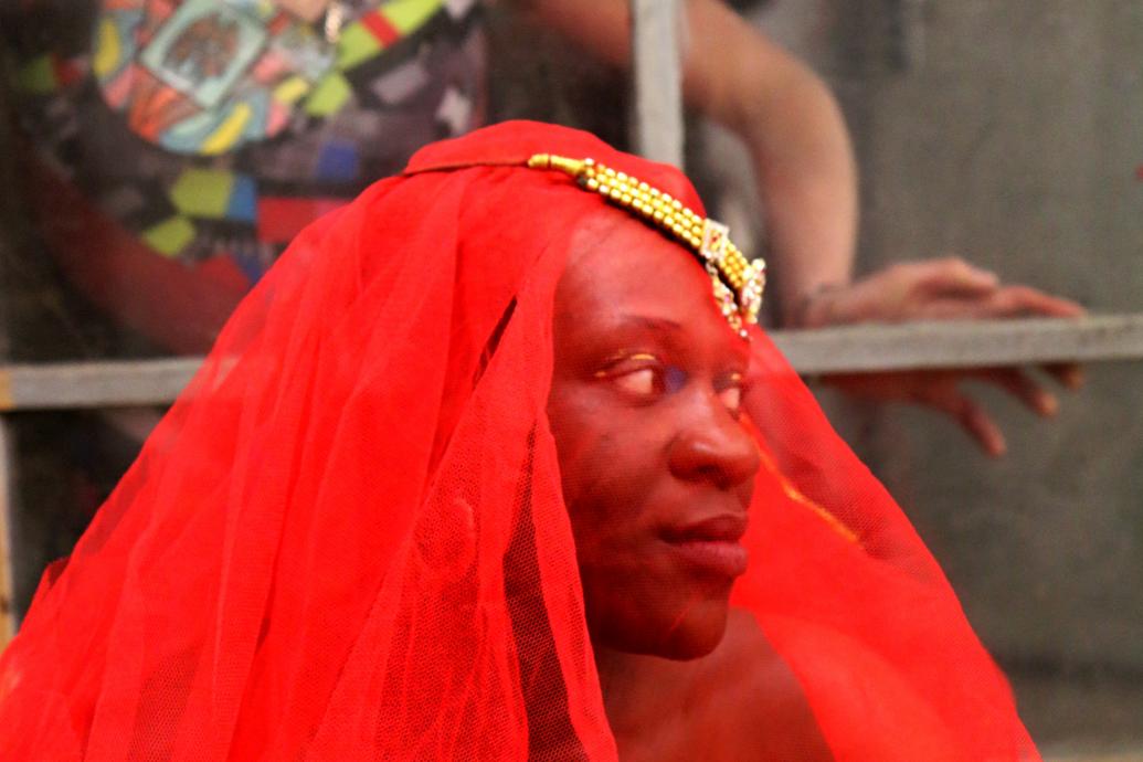 Black Jam, Woman wearing red veil, with woman looking through a window behind her