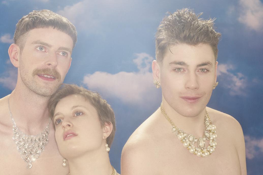 Three people standing against a heaven-like background