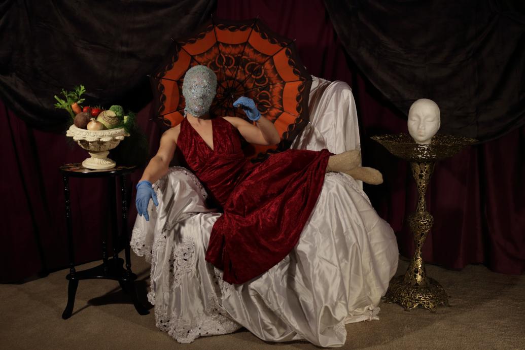Woman in red dress wearing a mask, lounging on a chair
