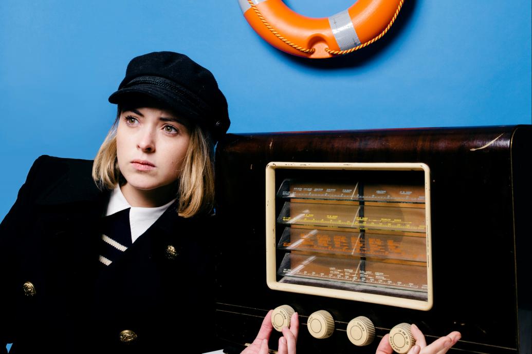 Image of lighthouse keeper turning dial on an old wireless radio