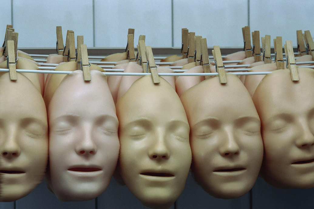 Multiple silicone faces handing from a line with a peg