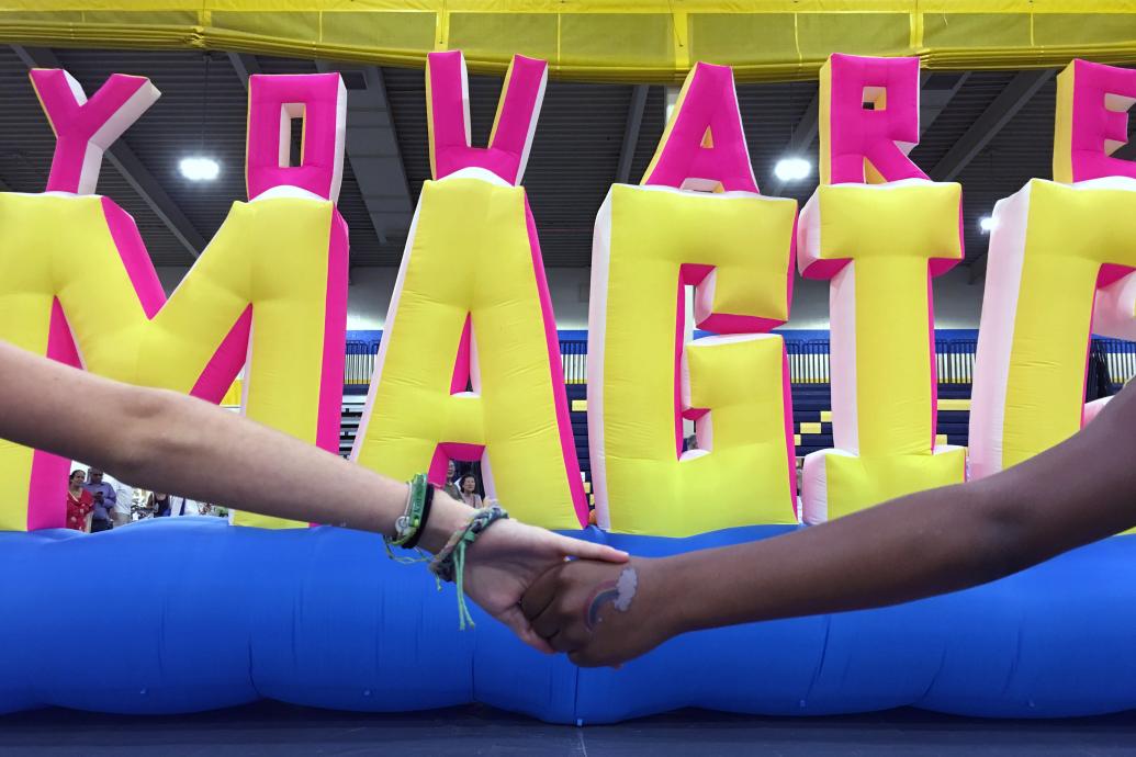 Two hands holding in front of inflatable artwork