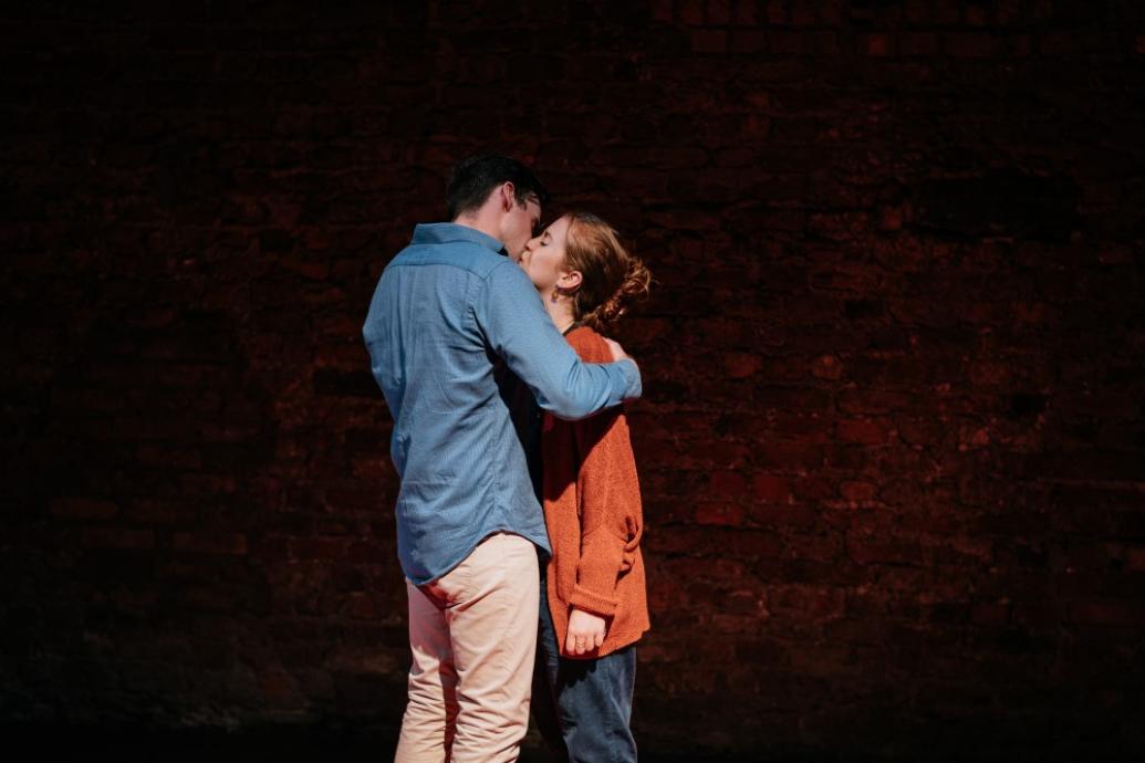 Male and female actor kiss on stage