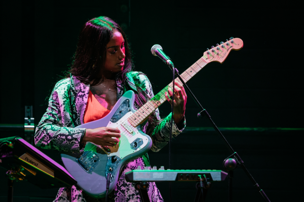 Fehdah playing guitar onstage