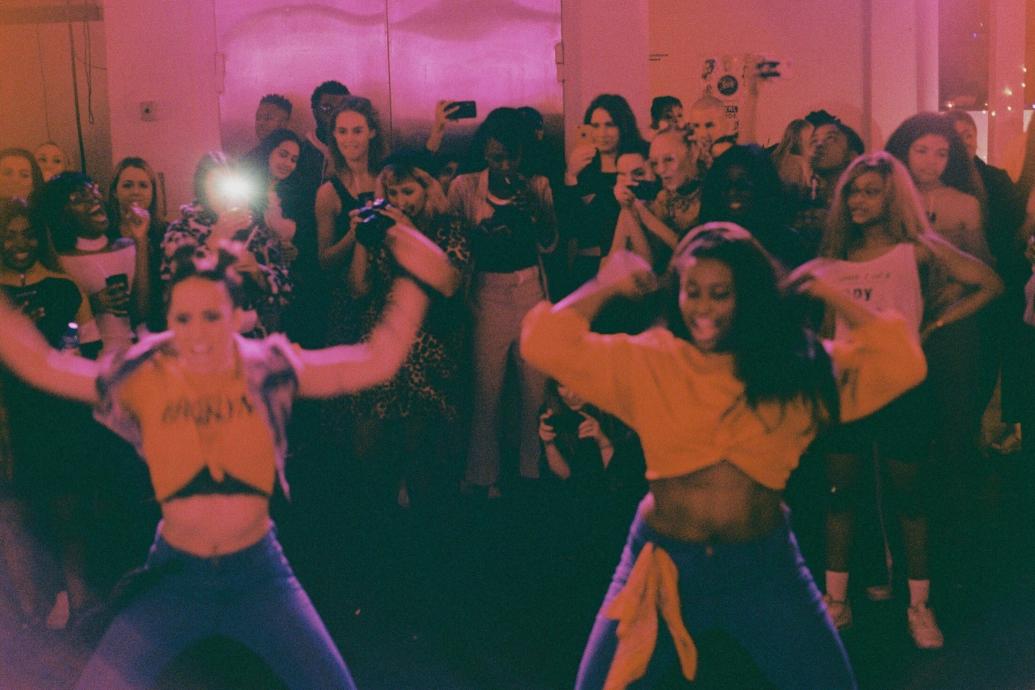 People dancing at a packed club night - red hue.