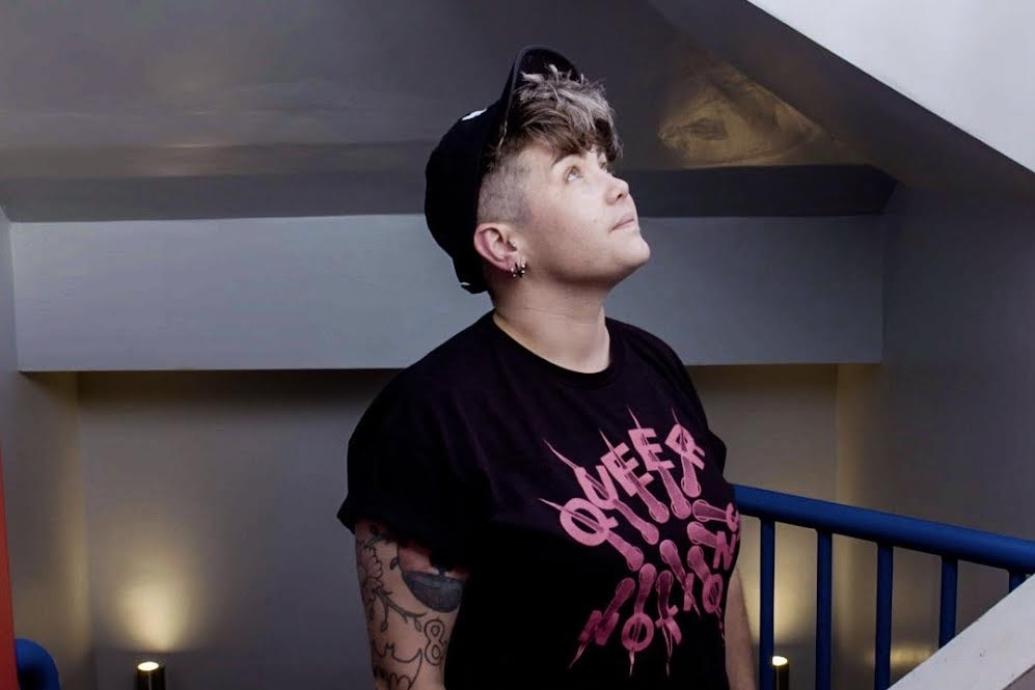 Photo of Ragin Spice DJ wearing a black and pink tshirt and a black cap.