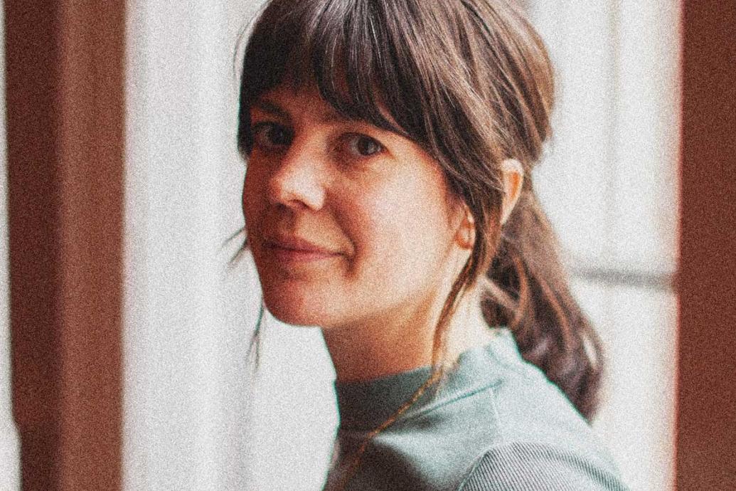 A headshot of a person against a bright window.