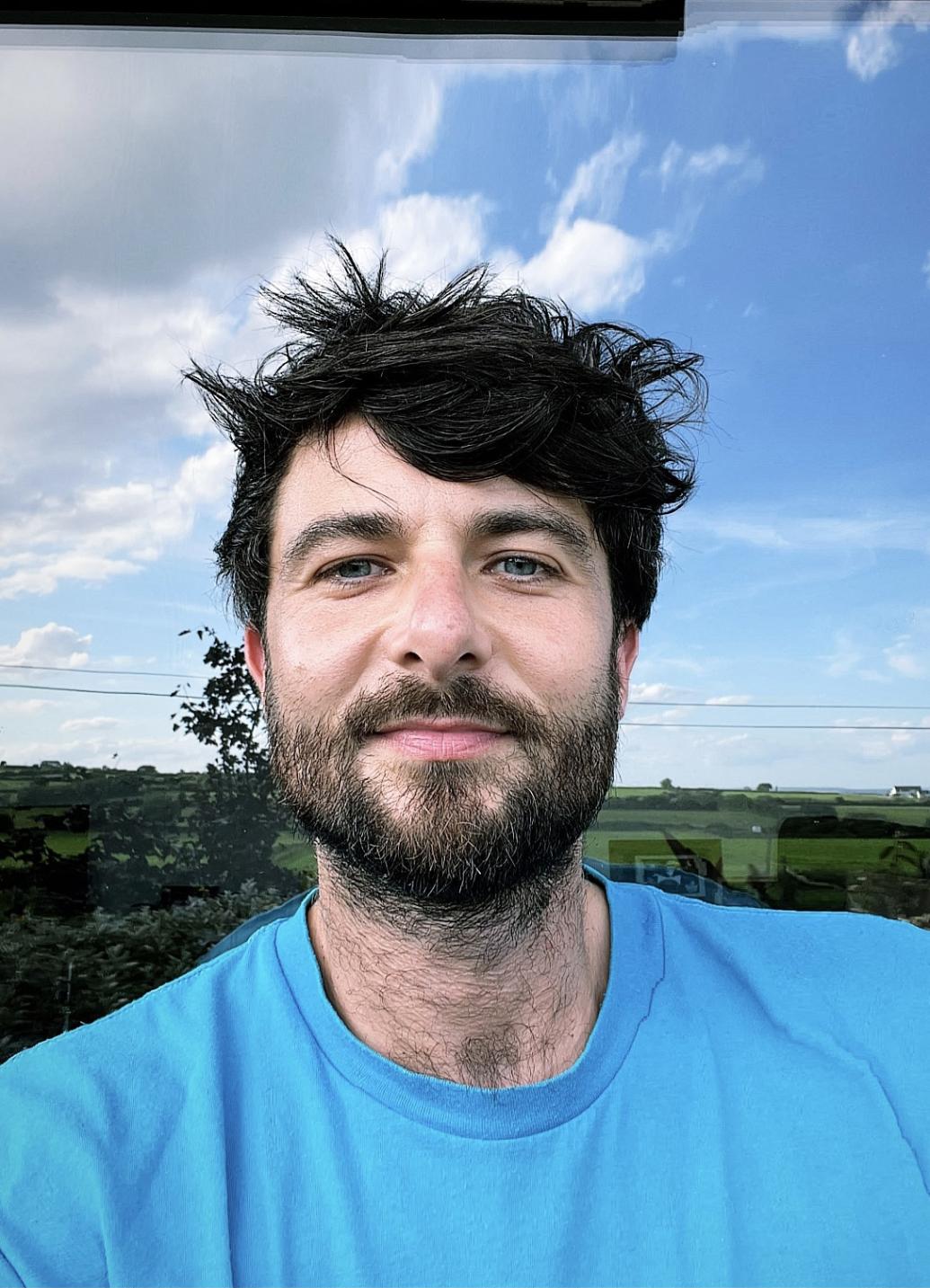 man in blue t shirts standing against sky