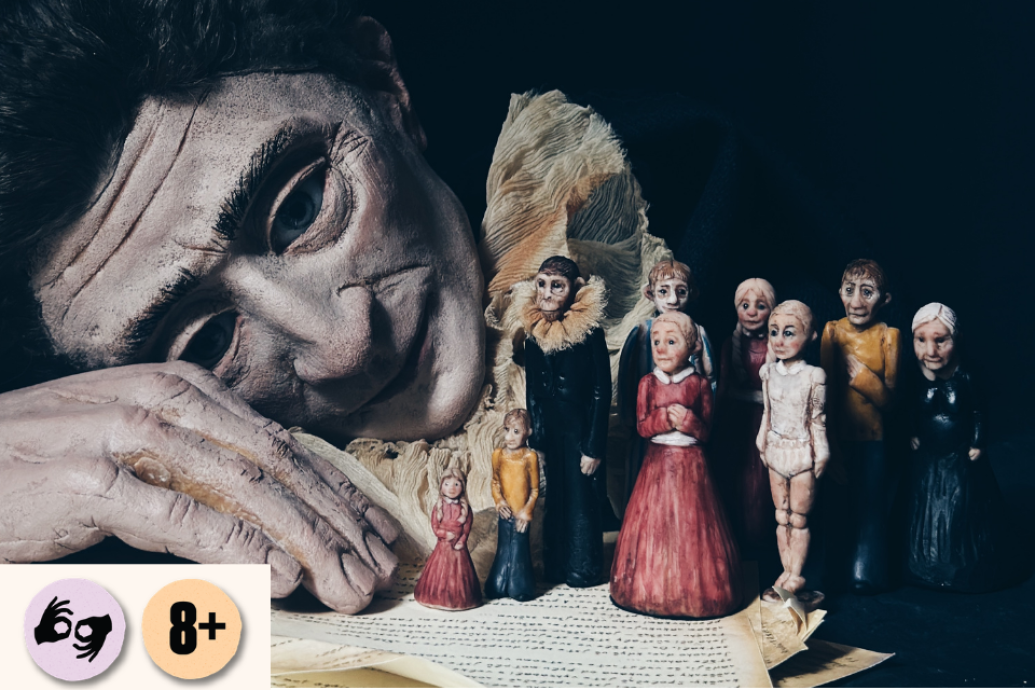 A large puppet-like figure rests its head beside a row of small hand-crafted dolls on a dark stage. Visible symbols: ISL and 8+.