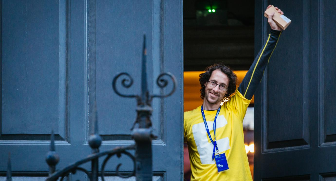 Dublin Fringe Volunteer holding tickets in air