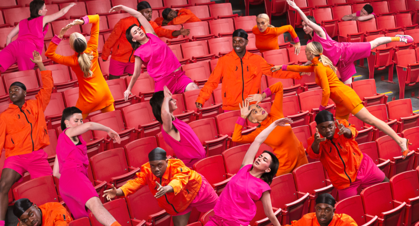 Many performers multiplied in various poses amongst theatre seating
