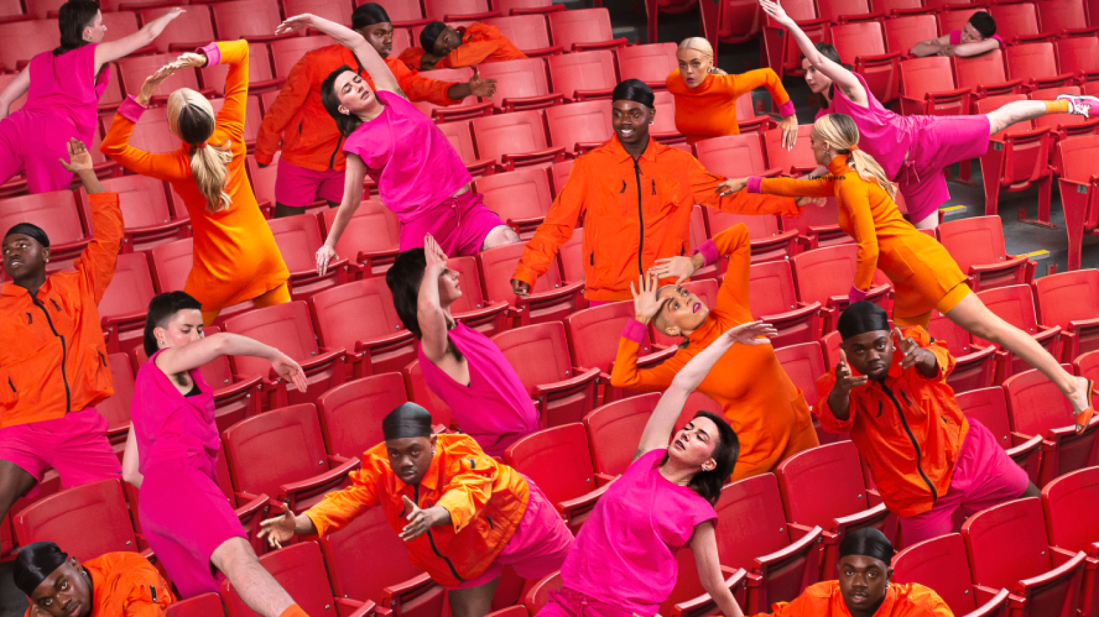 Multiples of performers in movement in the seats of a theatre